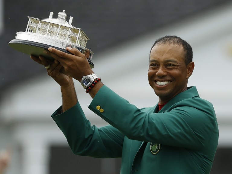Tiger Woods wears his green jacket holding the winning trophy after the final round for the Masters golf tournament_Ap images 4